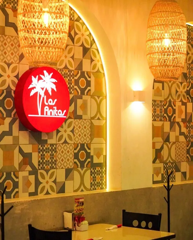 Arco con mosaico de pasta y el logo iluminado en el comedor
